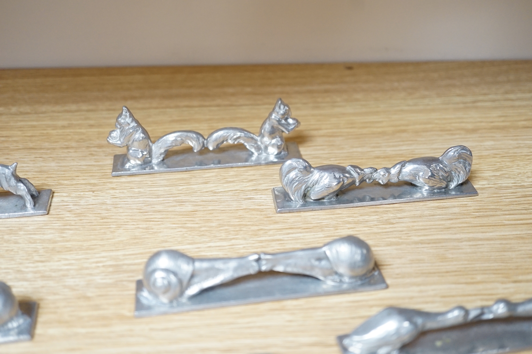 A set of 12 French pewter novelty knife rests, in the form of squirrels, fish, snails, goats, etc.